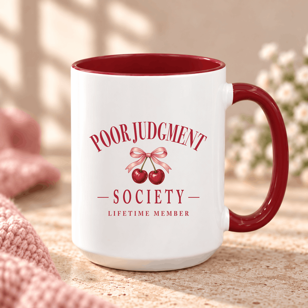 Poor Judgment Society Lifetime Member mug in Maroon on a marble counter with pink knit and flowers