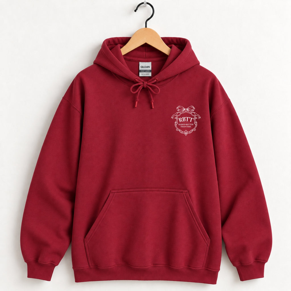 Raised Better Than This crest hoodie in Cardinal Red on a wooden hanger