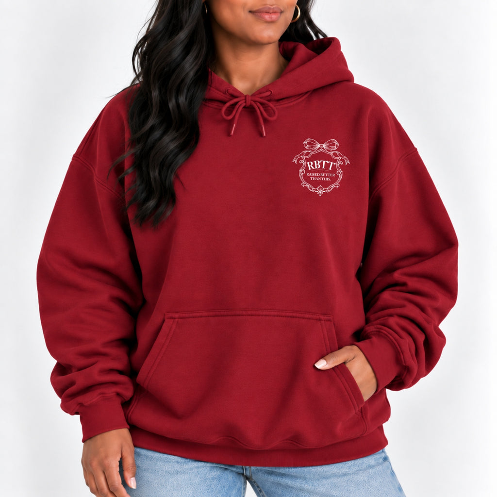 Woman wearing the Raised Better Than This crest hoodie in Cardinal Red with jeans