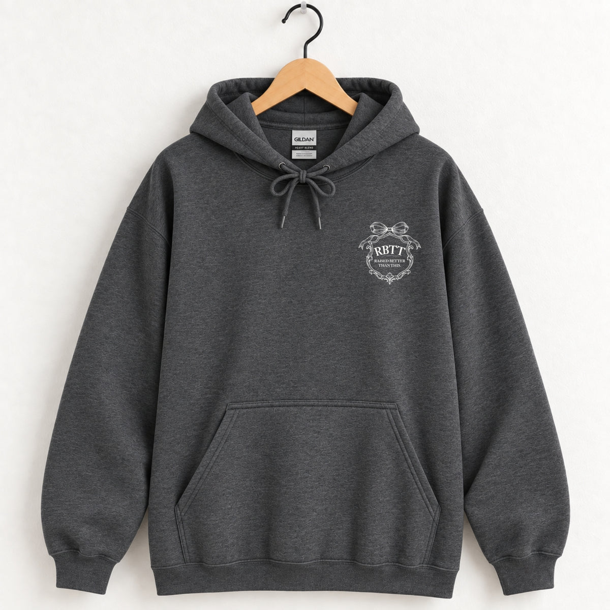 Raised Better Than This crest hoodie in Dark Heather on a wooden hanger