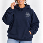 Woman wearing the Raised Better Than This crest hoodie in Navy with jeans