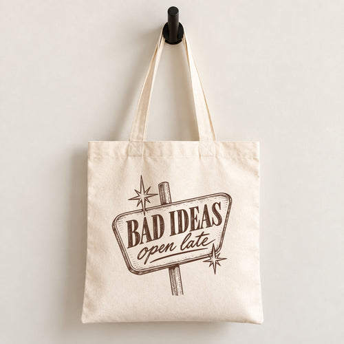 Bad Ideas, Open Late canvas tote bag hanging on a wall hook, retro sign printed in brown