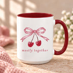 Mostly Together cherry bow mug with maroon handle and interior on a stone counter