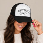 Woman in a cream sweatshirt tipping the brim of the Respectfully, No trucker hat in Black with a white front panel