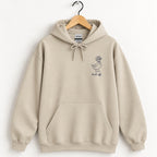 Duck Off hoodie in Sand on a wooden hanger, small navy duck on the left chest