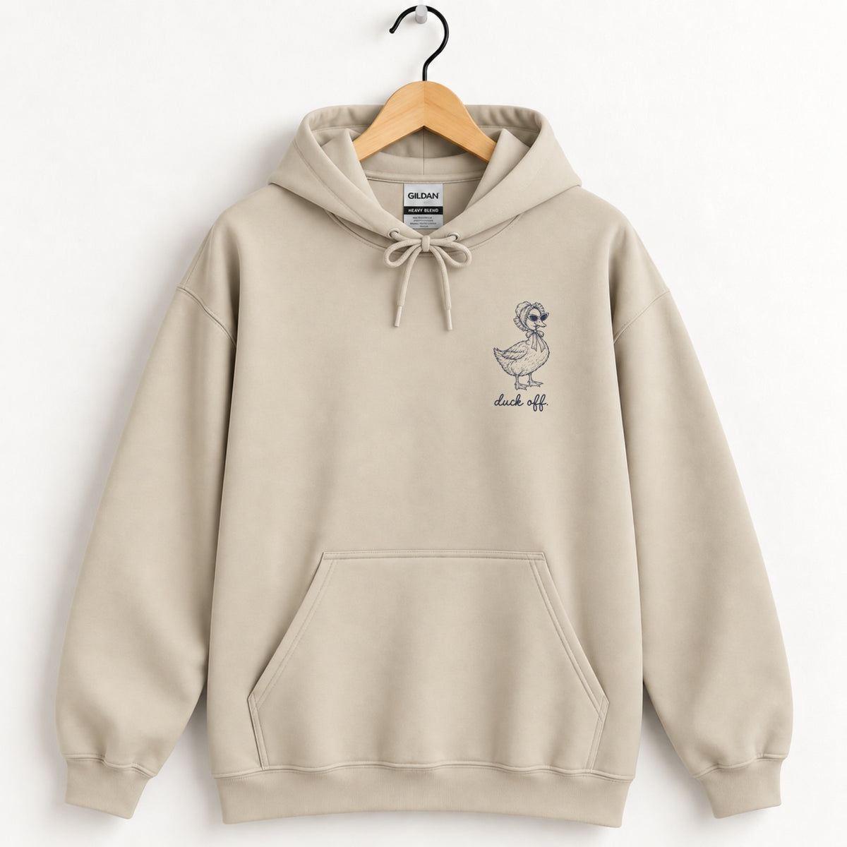 Duck Off hoodie in Sand on a wooden hanger, small navy duck on the left chest