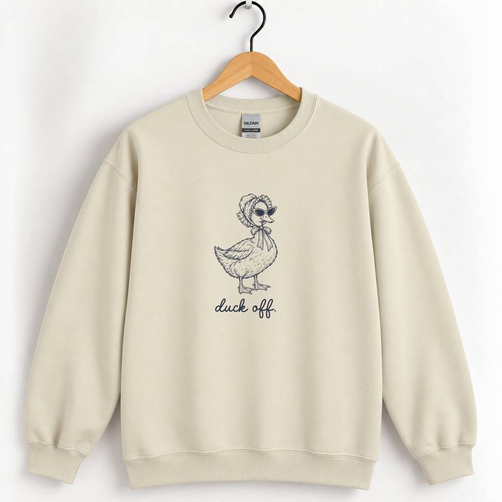 Duck Off crewneck sweatshirt in Sand on a wooden hanger, navy duck in a bonnet and sunglasses printed center chest
