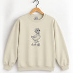 Duck Off crewneck sweatshirt in Sand on a wooden hanger, navy duck in a bonnet and sunglasses printed center chest