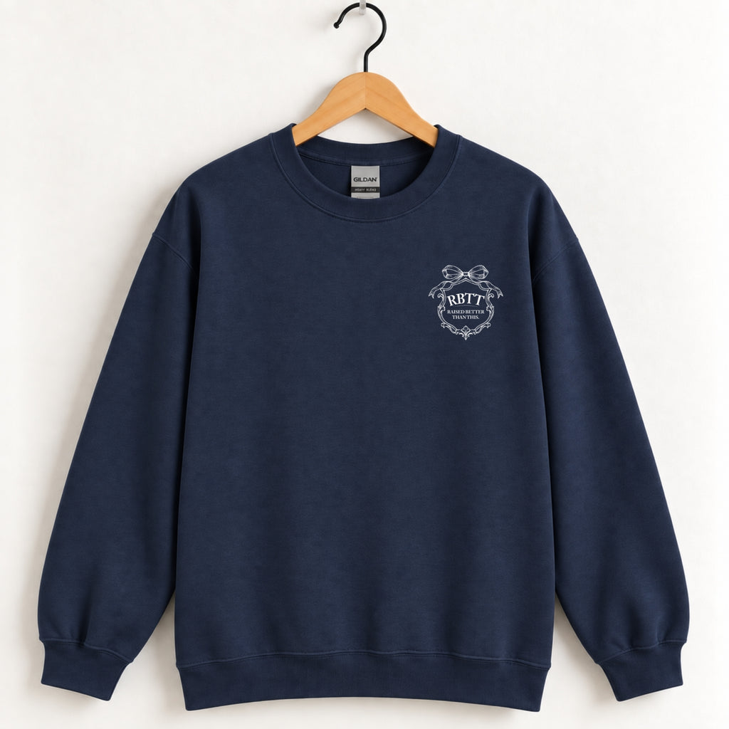 Raised Better Than This crest crewneck sweatshirt in Navy on a wooden hanger, white left-chest crest