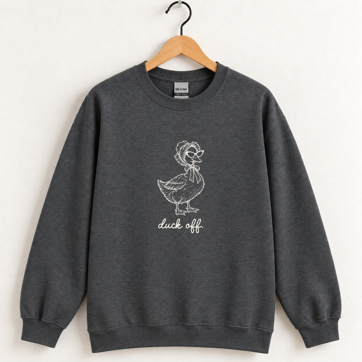 Duck Off crewneck sweatshirt in Dark Heather on a wooden hanger, white duck design center chest