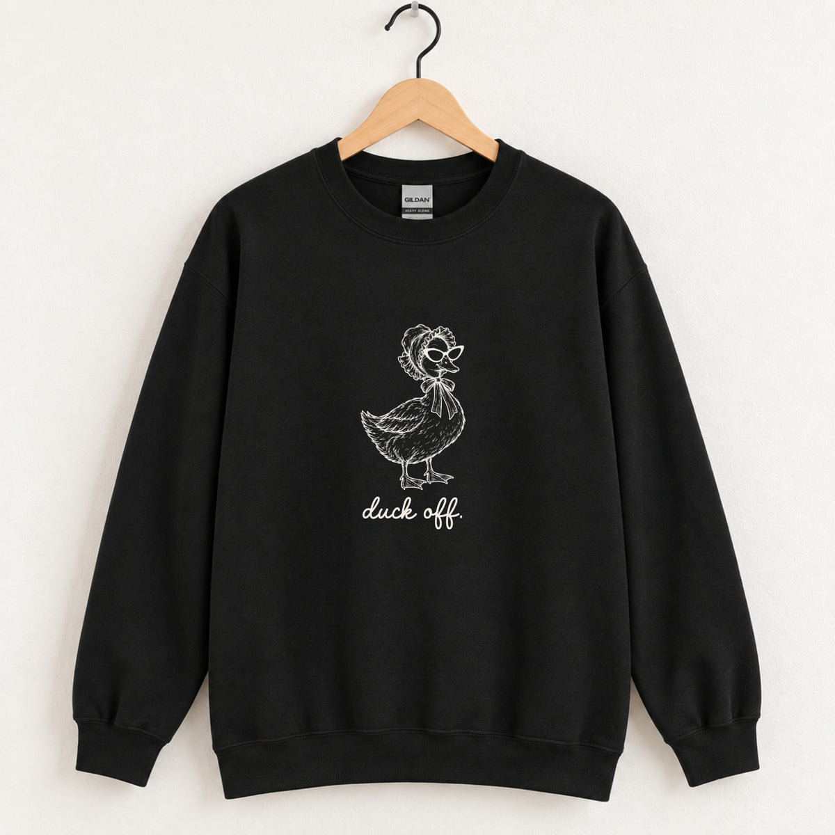 Duck Off crewneck sweatshirt in Black on a wooden hanger, white duck design center chest