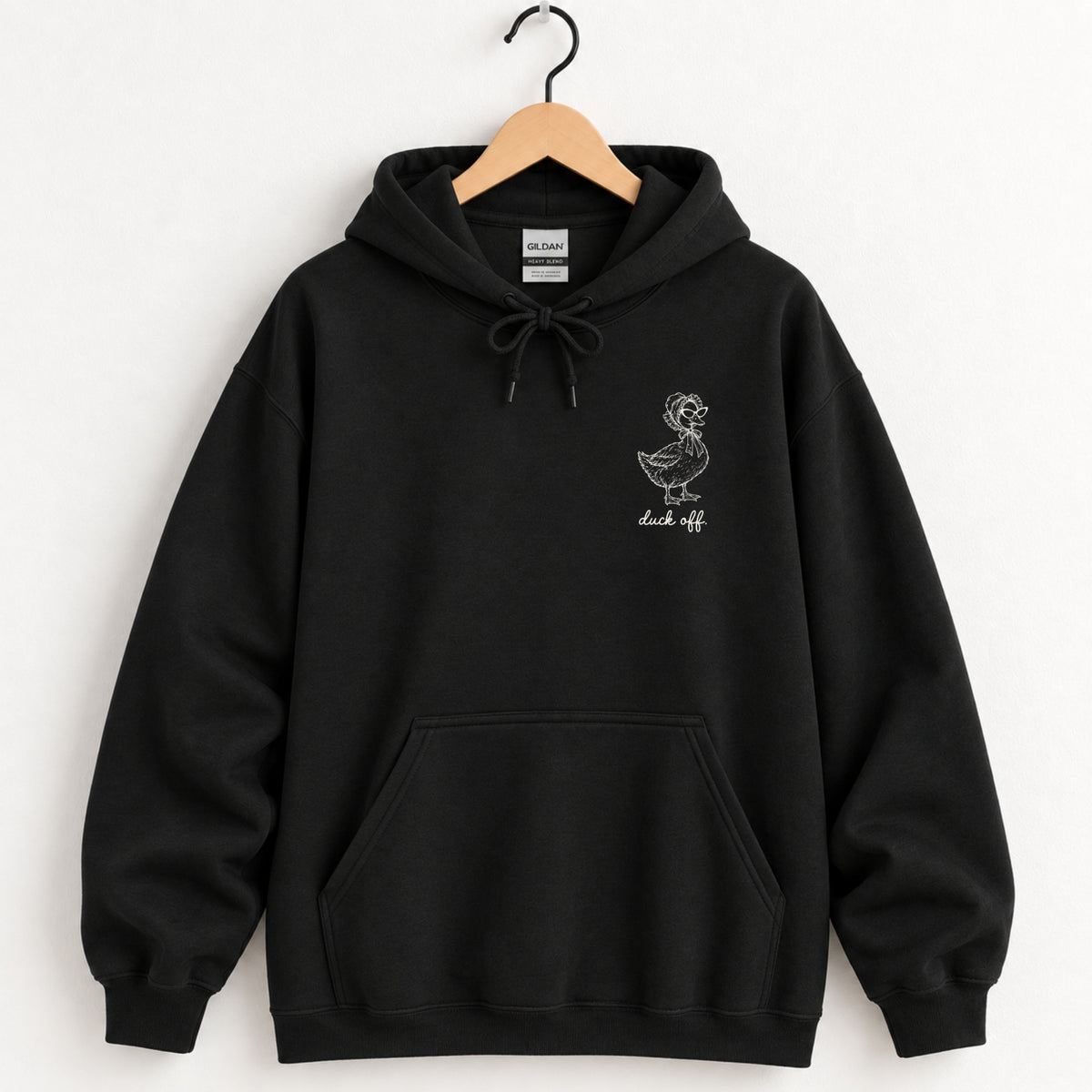 Duck Off hoodie in Black on a wooden hanger, small white duck on the left chest