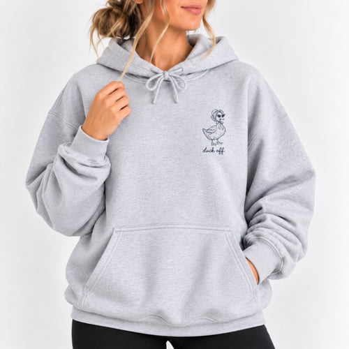 Woman wearing the Duck Off hoodie in Ash, left-chest navy duck design