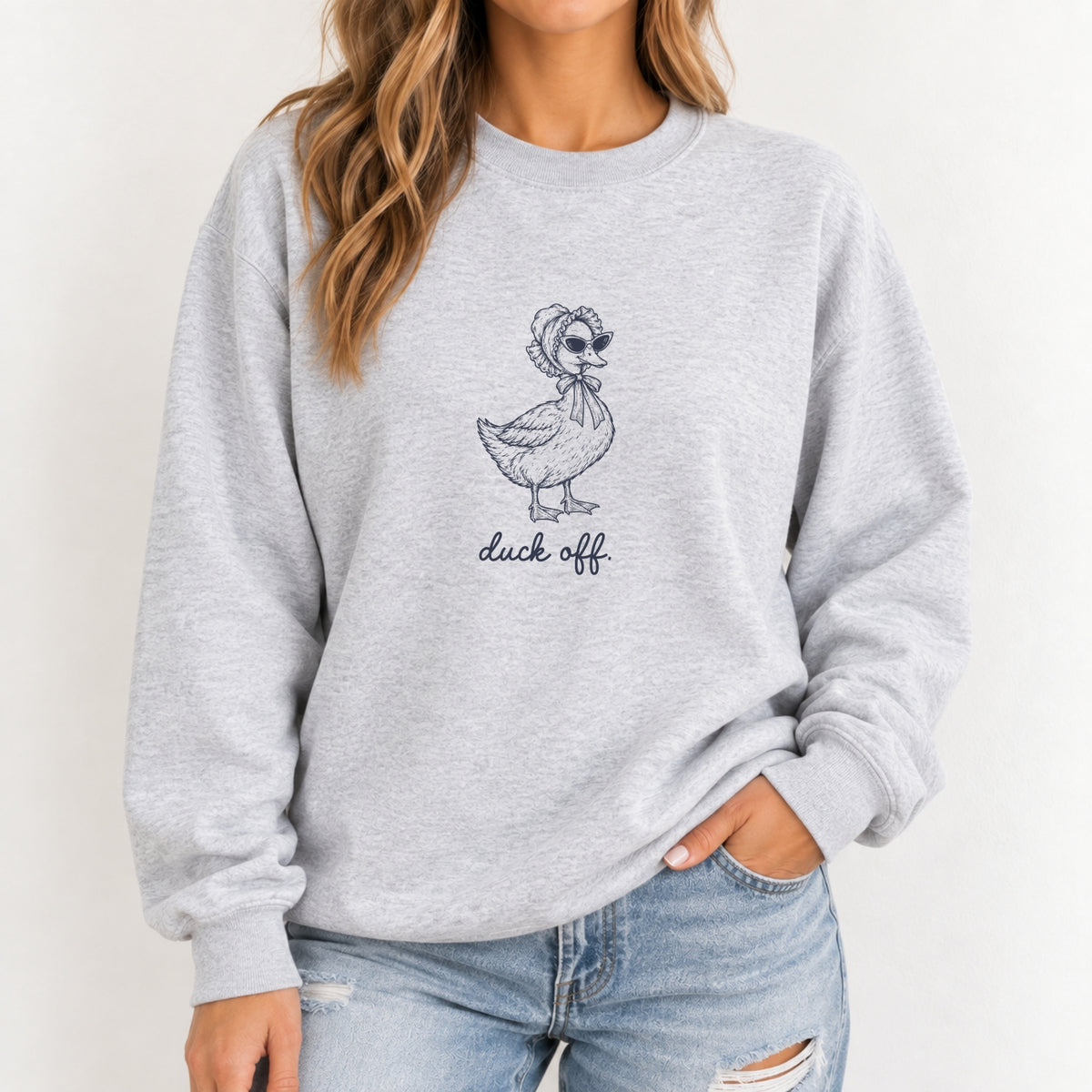 Woman wearing the Duck Off crewneck sweatshirt in Ash, navy duck design on the chest