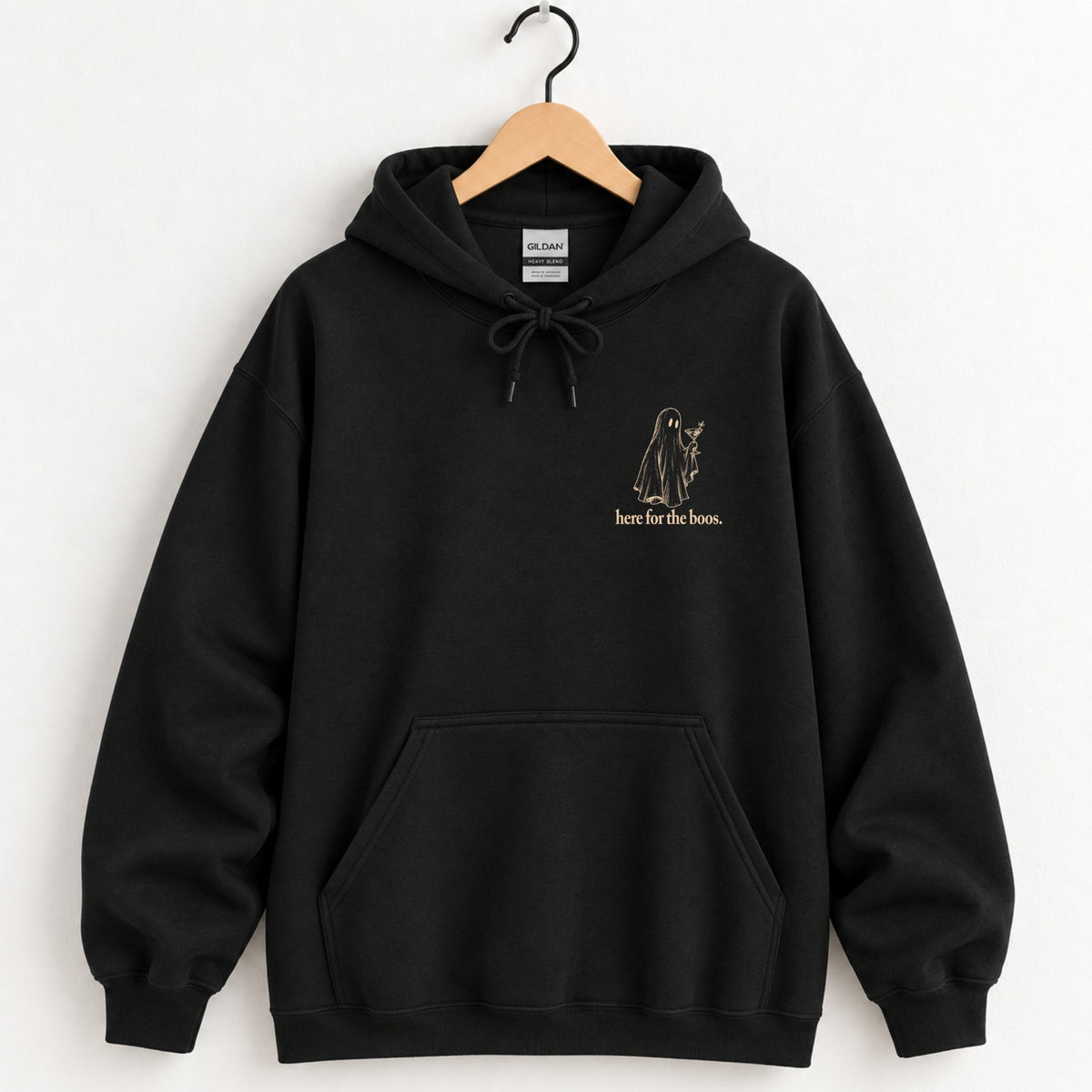 Here for the Boos hoodie in Black on a wooden hanger, ivory ghost with a martini on the left chest