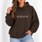Woman wearing the Jack-o-lantern embroidered hoodie in Dark Chocolate with jeans, ivory thread pumpkins