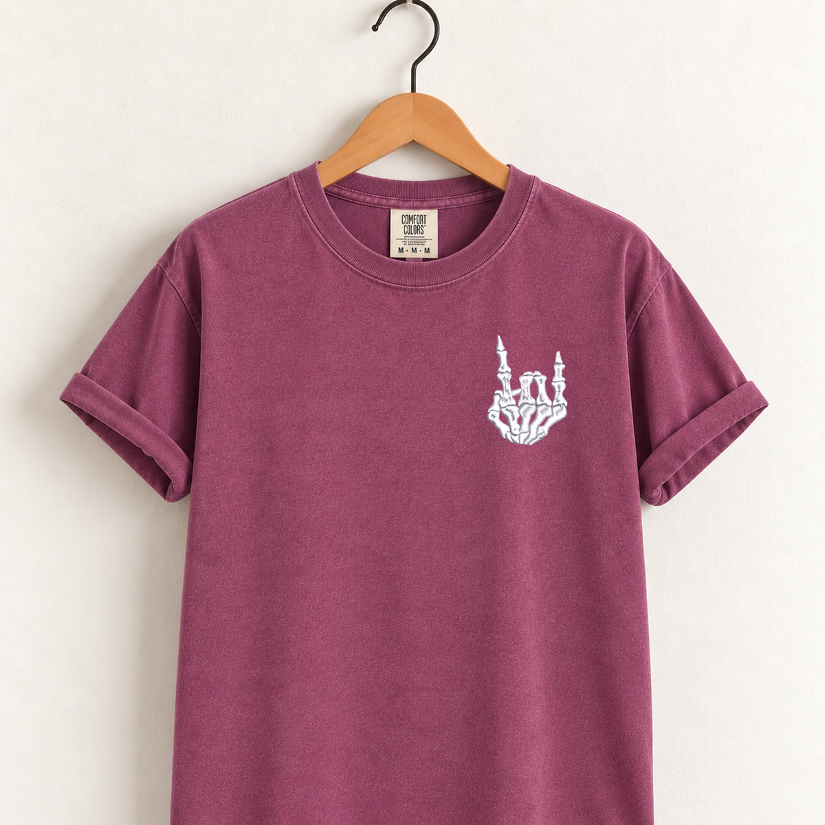 Rock on skeleton hand embroidered tee in Berry on a wooden hanger
