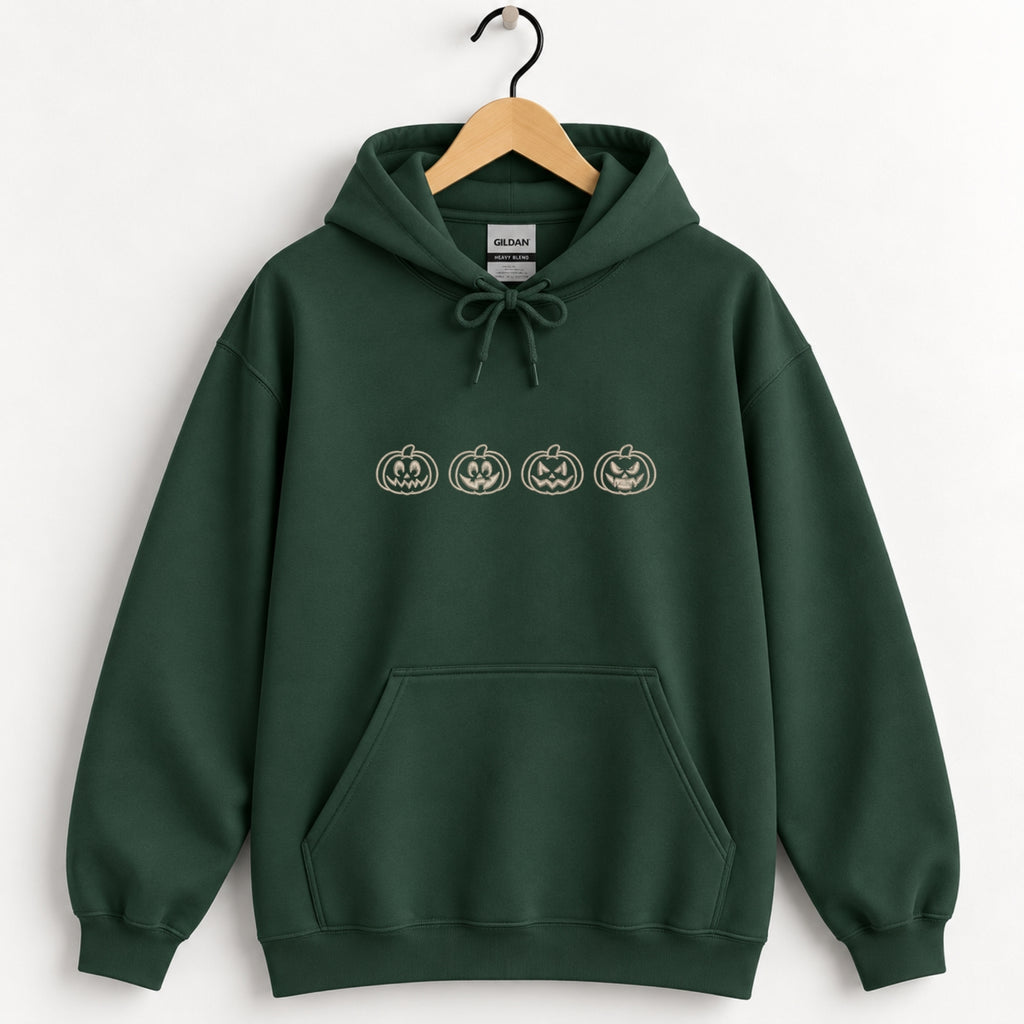Jack-o-lantern embroidered hoodie in Forest Green on a wooden hanger, ivory thread pumpkins