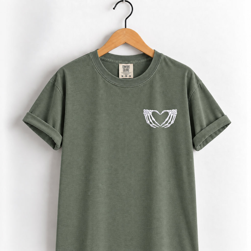 Heart hands skeleton embroidered tee in Moss on a wooden hanger