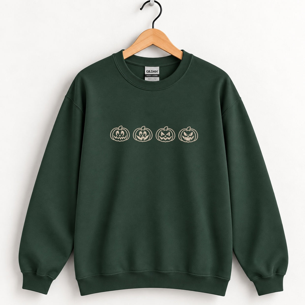 Jack-o-lantern embroidered crewneck sweatshirt in Forest Green on a wooden hanger