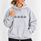 Woman wearing the Jack-o-lantern embroidered hoodie in Ash with jeans, black thread pumpkins