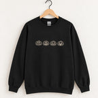 Jack-o-lantern embroidered crewneck sweatshirt in Black on a wooden hanger, four ivory pumpkins across the chest