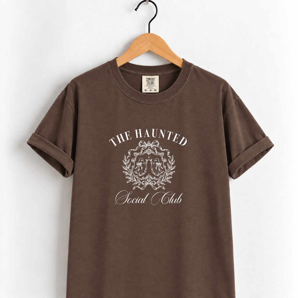 The Haunted Social Club tee in Espresso on a wooden hanger