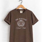 The Haunted Social Club tee in Espresso on a wooden hanger