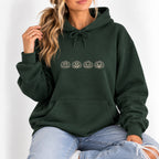Woman wearing the Jack-o-lantern embroidered hoodie in Forest Green with jeans, ivory thread pumpkins