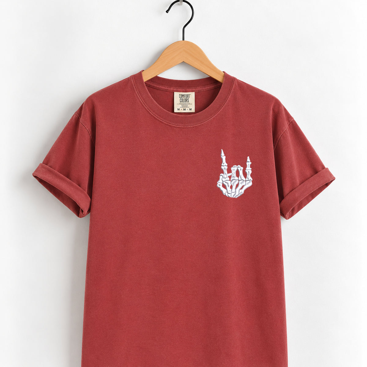 Rock on skeleton hand embroidered tee in Chili on a wooden hanger