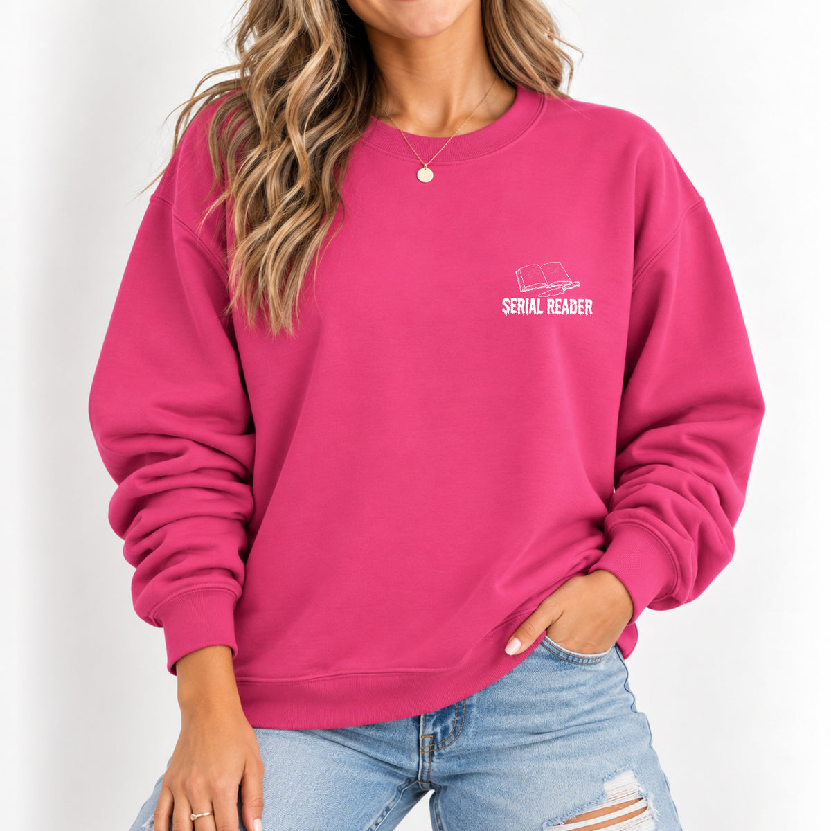 Woman wearing the Serial Reader crewneck sweatshirt in Heliconia pink with jeans