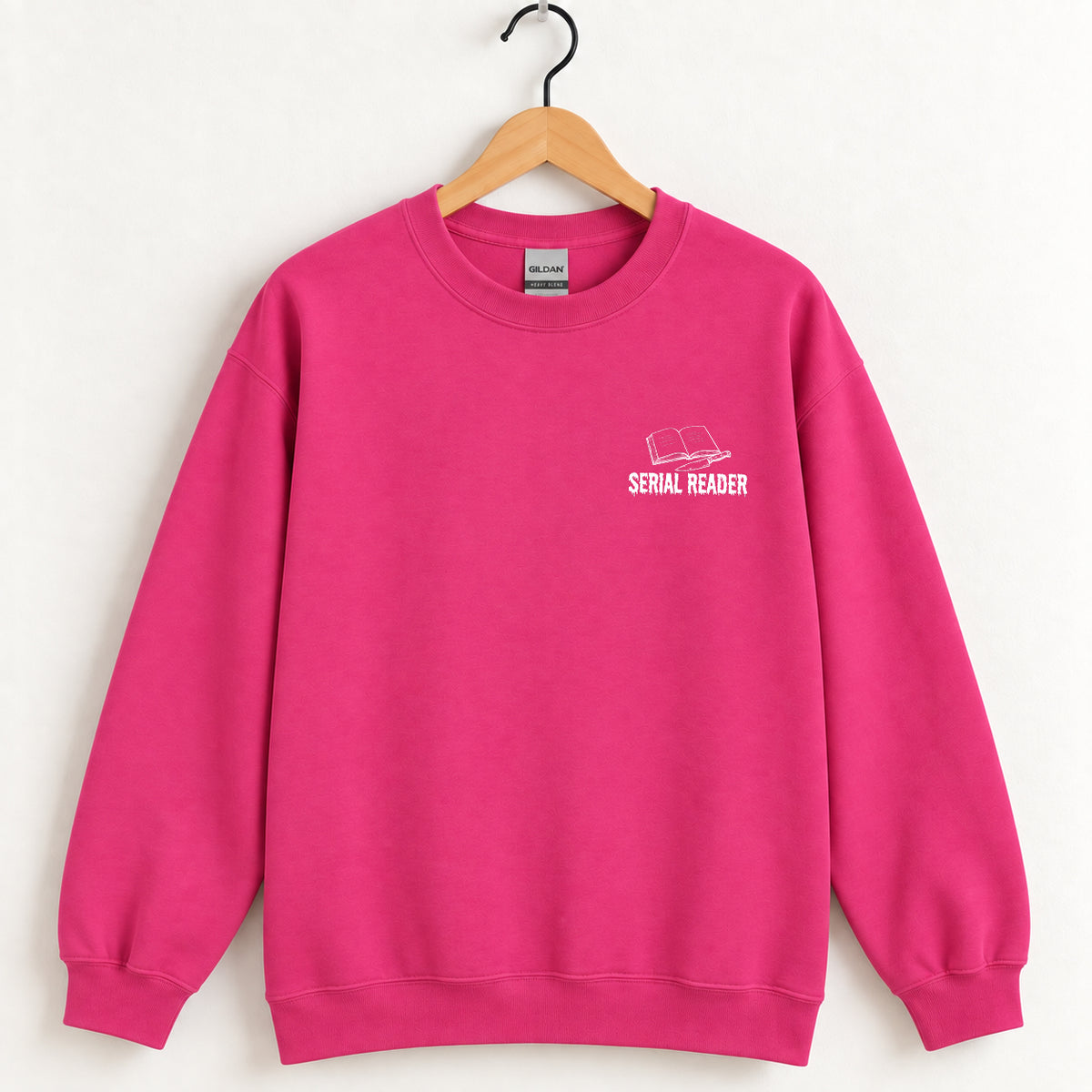 Serial Reader crewneck sweatshirt in Heliconia pink on a wooden hanger