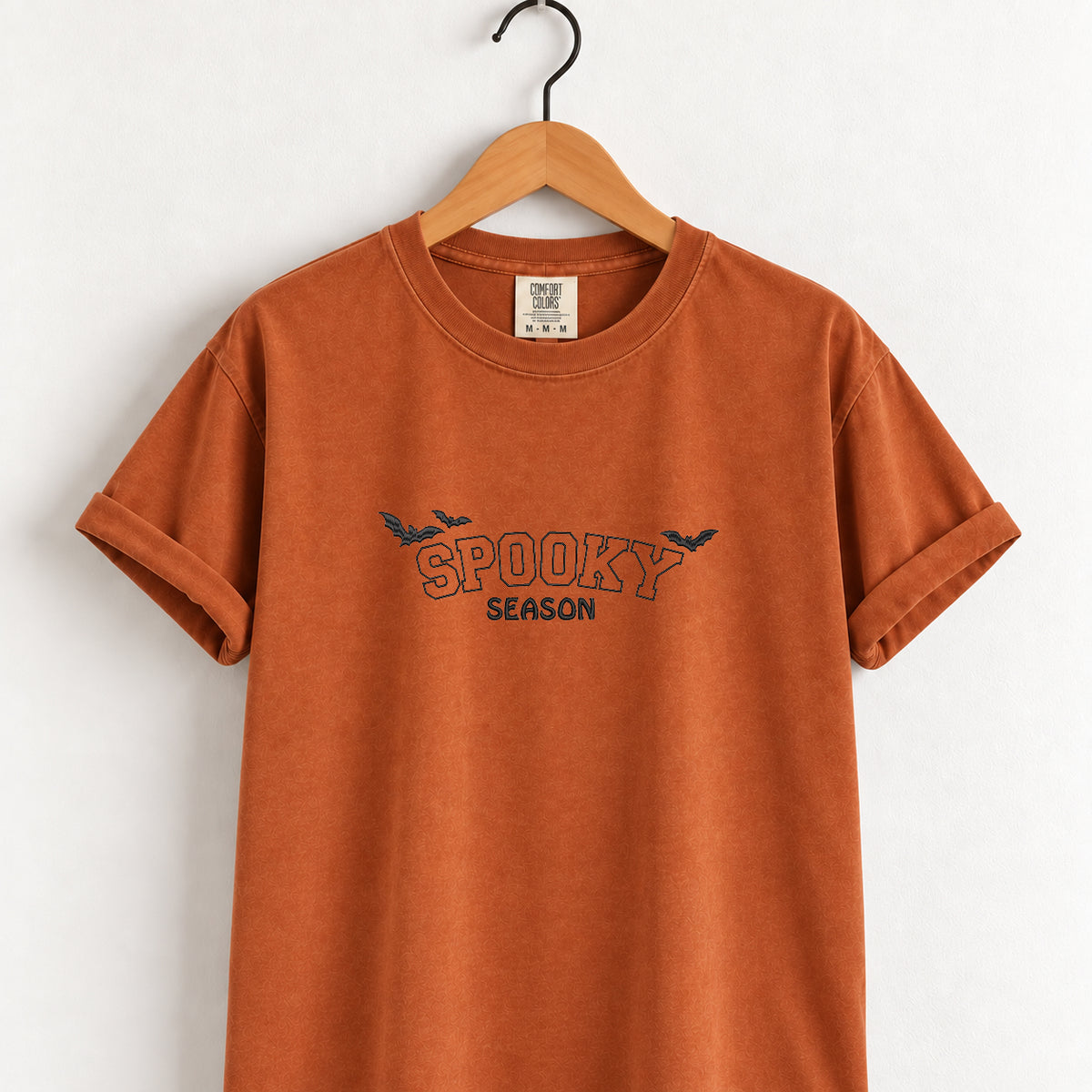 Spooky Season embroidered tee in Yam on a wooden hanger