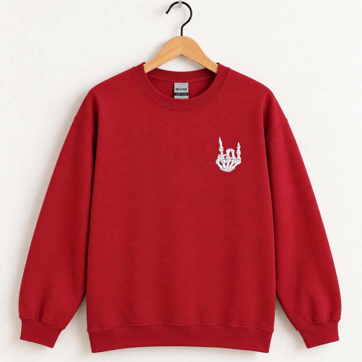 Rock On Skeleton Hand embroidered crewneck sweatshirt in Cardinal Red on a wooden hanger