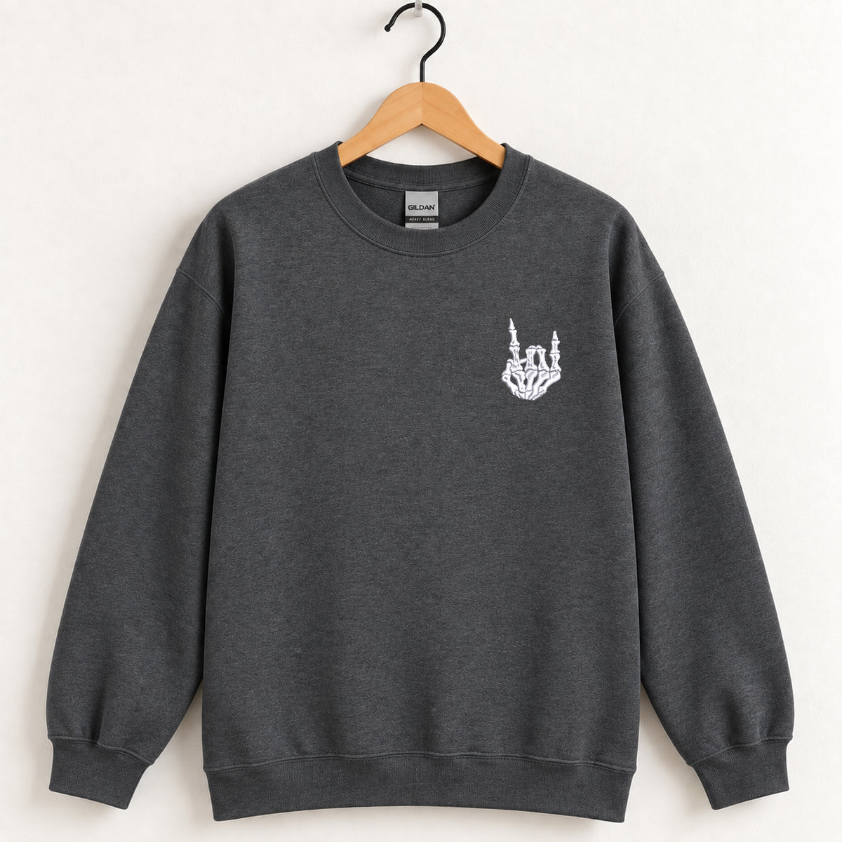 Rock On Skeleton Hand embroidered crewneck sweatshirt in Dark Heather on a wooden hanger