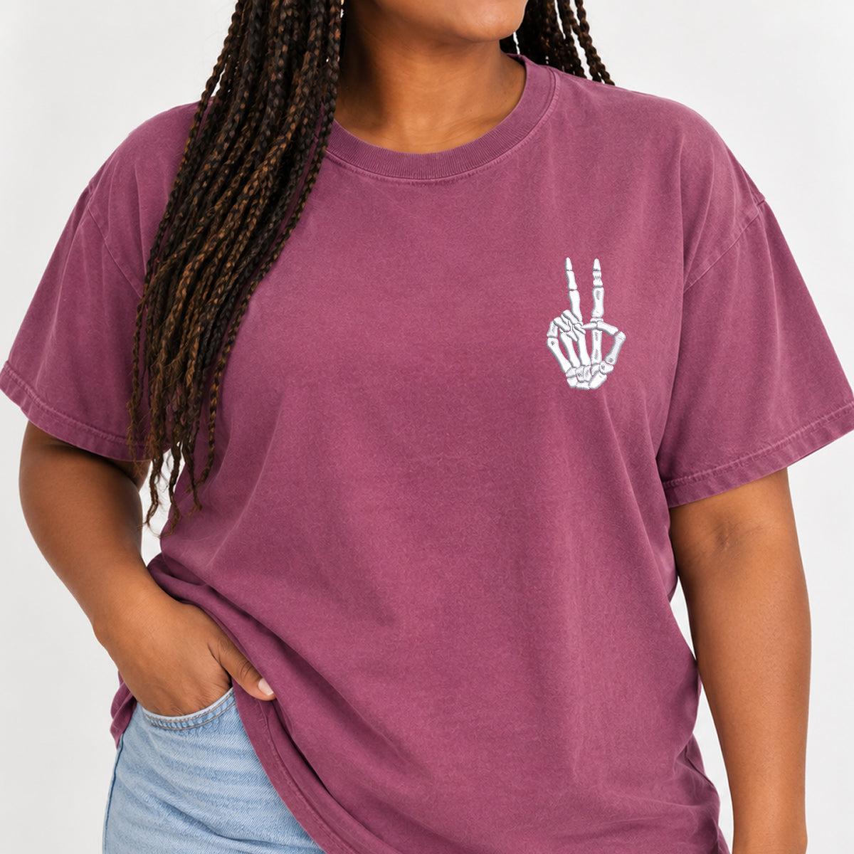 Woman with braids wearing the peace sign skeleton hand embroidered tee in Berry