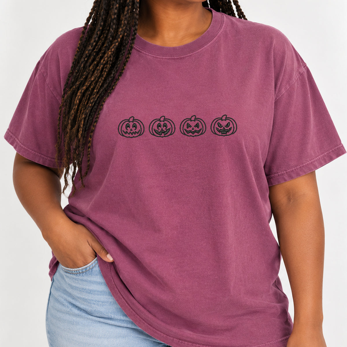 Woman with braids wearing the jack-o-lantern embroidered tee in Berry