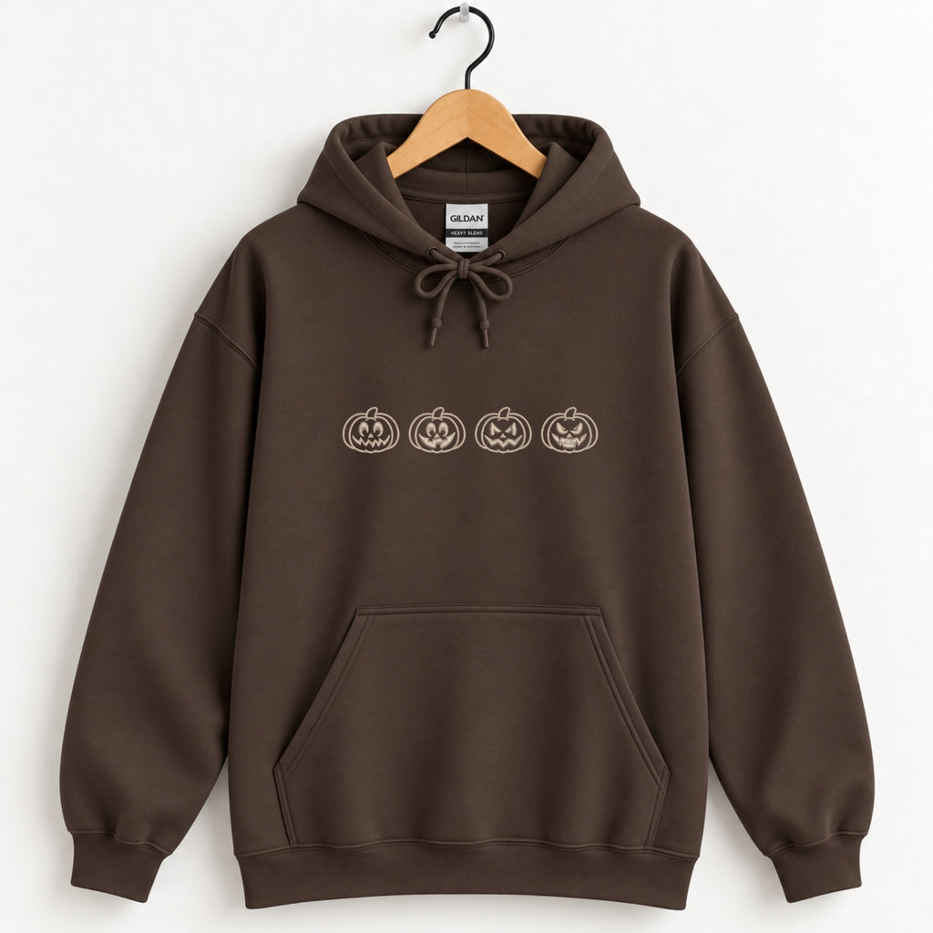 Jack-o-lantern embroidered hoodie in Dark Chocolate on a wooden hanger, ivory thread pumpkins