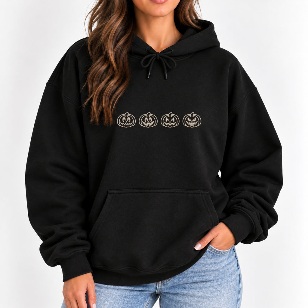 Woman wearing the Jack-o-lantern embroidered hoodie in Black with jeans, ivory thread pumpkins