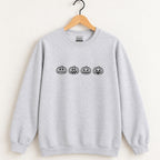 Jack-o-lantern embroidered crewneck sweatshirt in Ash on a wooden hanger, black thread pumpkins