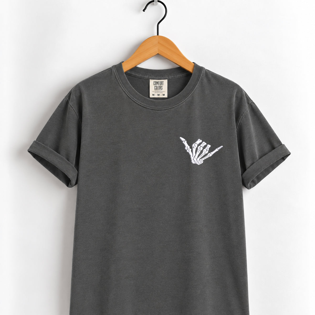 Shaka skeleton hand embroidered tee in Pepper on a wooden hanger