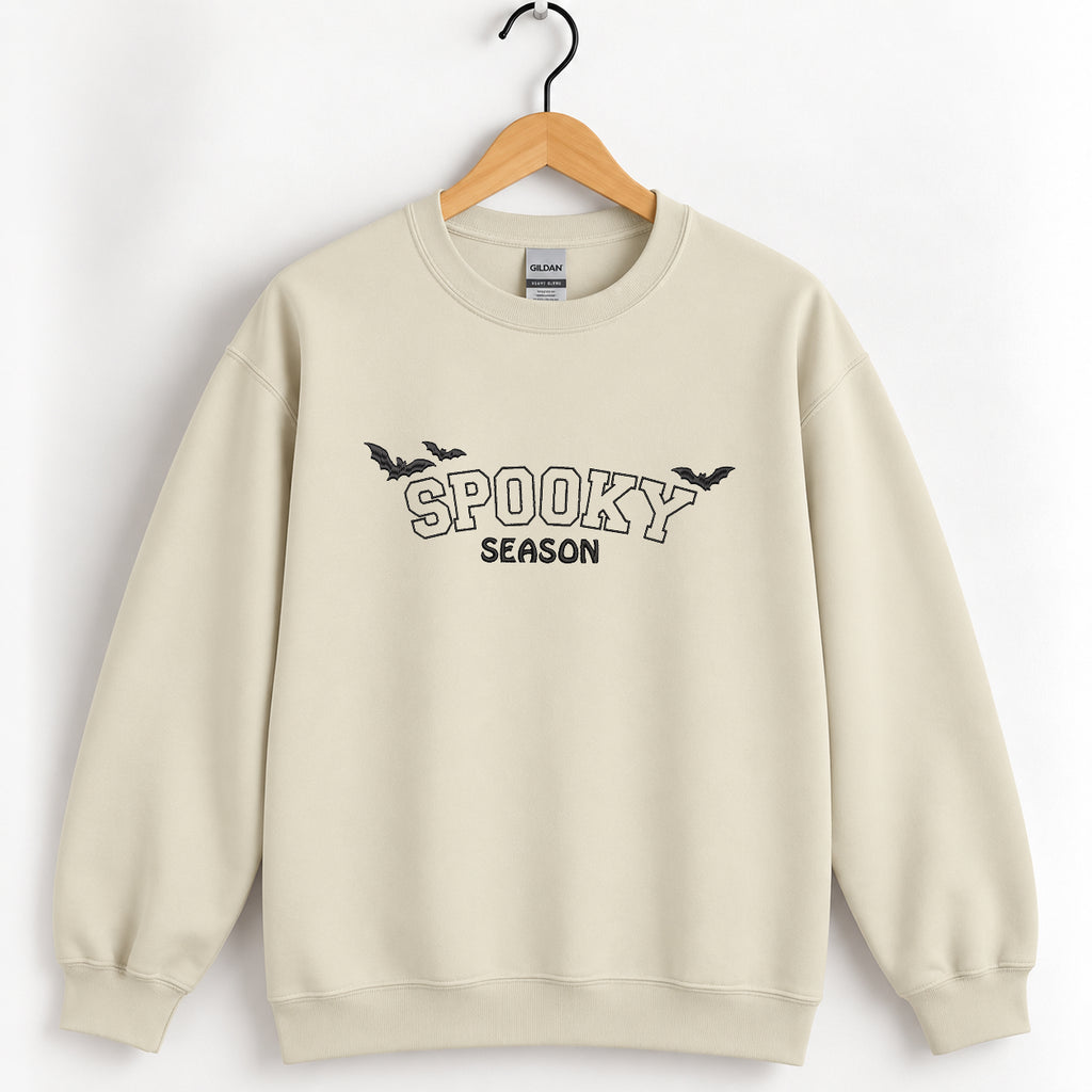 Spooky Season embroidered crewneck sweatshirt in Sand on a wooden hanger, black thread