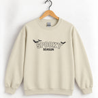 Spooky Season embroidered crewneck sweatshirt in Sand on a wooden hanger, black thread