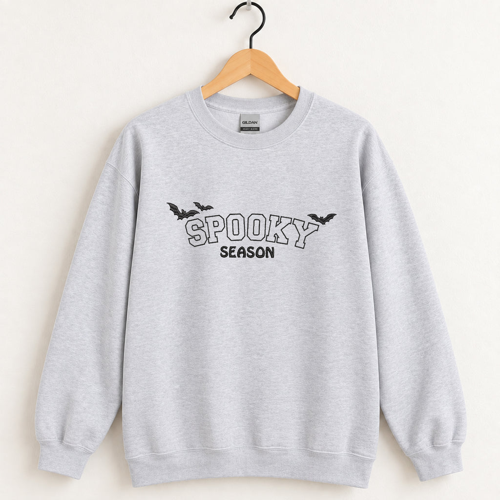 Spooky Season embroidered crewneck sweatshirt in Ash on a wooden hanger, black thread