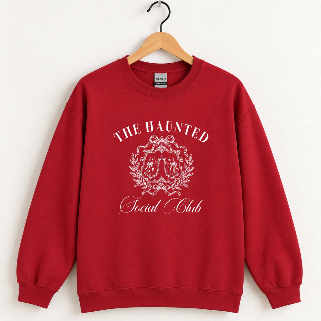 The Haunted Social Club crewneck sweatshirt in Cardinal Red on a wooden hanger