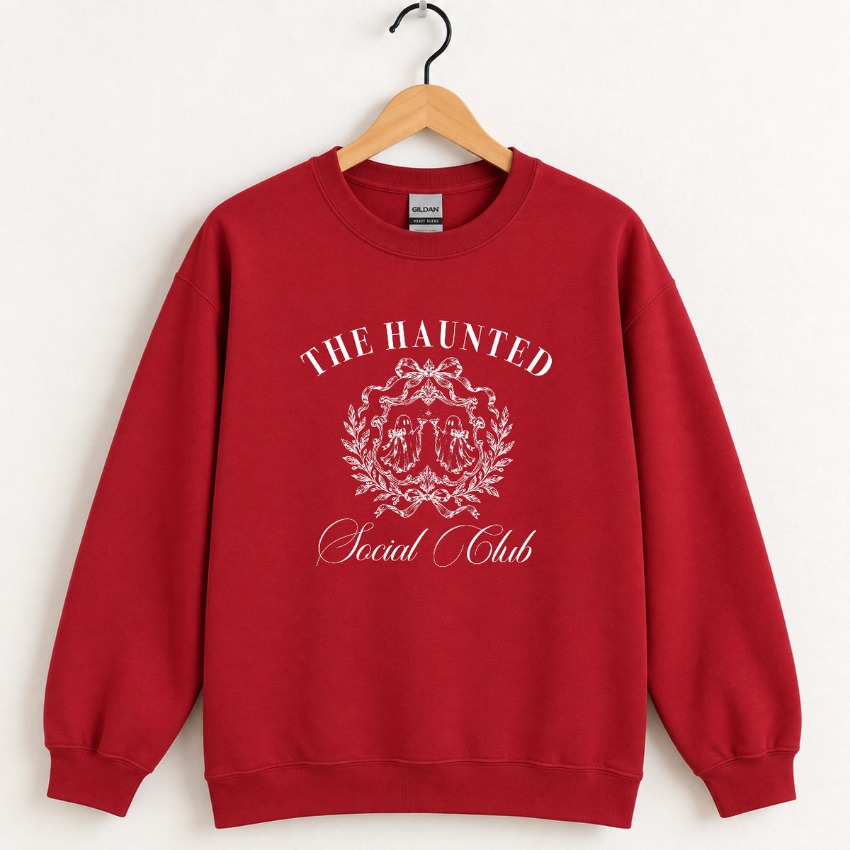 The Haunted Social Club crewneck sweatshirt in Cardinal Red on a wooden hanger