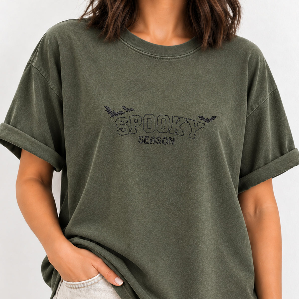 Woman wearing the Spooky Season embroidered bats tee in Moss