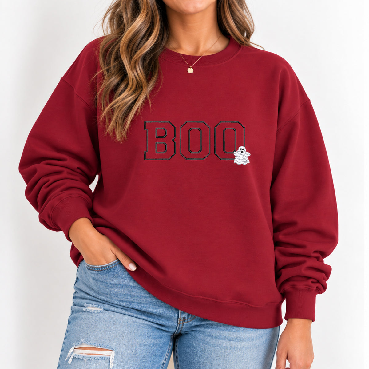 Woman wearing the Boo embroidered crewneck sweatshirt in Cardinal Red with jeans