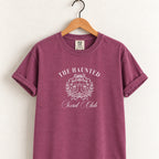 The Haunted Social Club tee in Berry on a wooden hanger