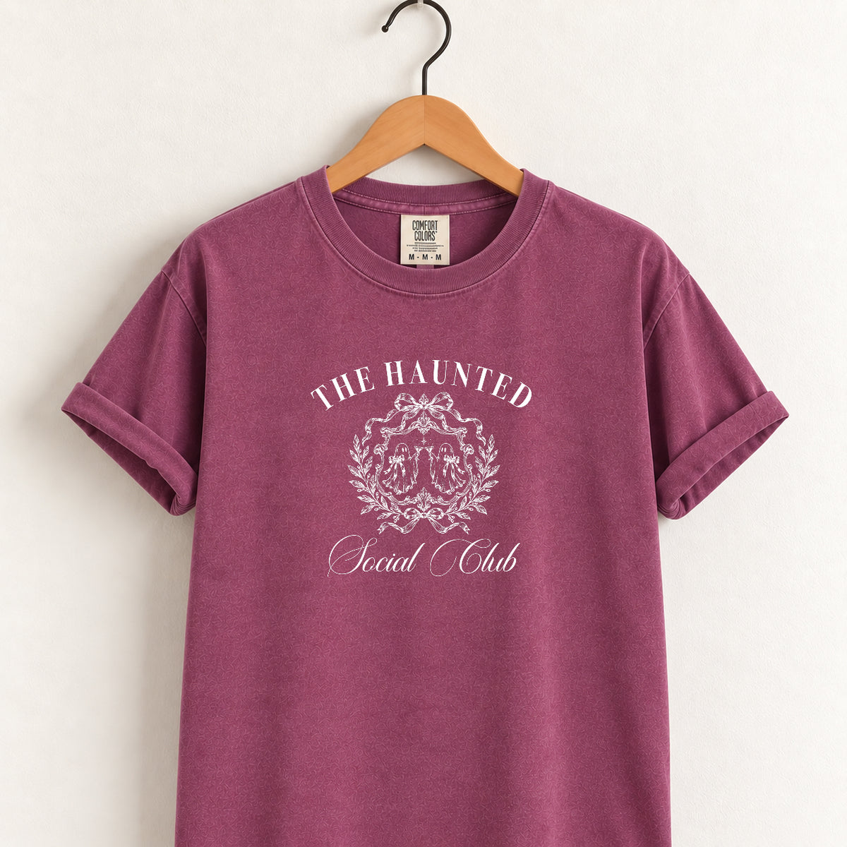 The Haunted Social Club tee in Berry on a wooden hanger